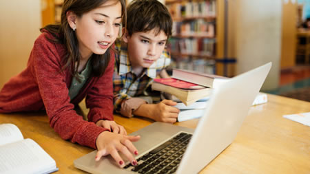 Young Girl and Boy Using Laptop