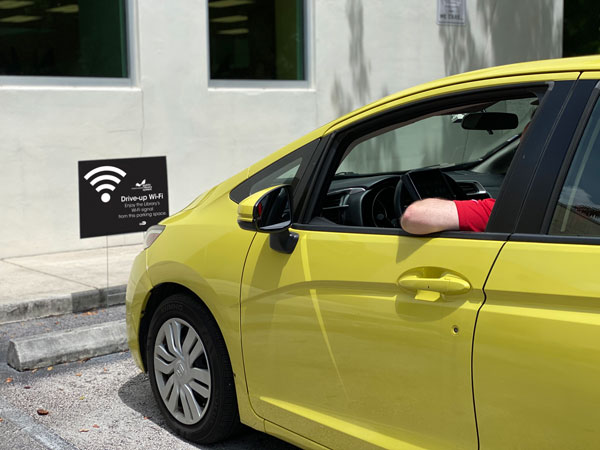 Car shown parked in spot with wi-fi designating signage
