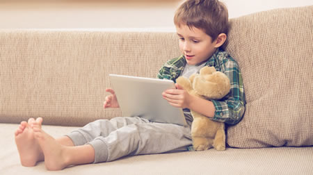 Boy on Couch Using Tablet